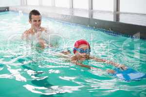 Cute little boy learning to swim with coach