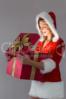 Pretty santa girl opening a gift