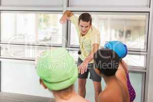 Swimming coach with his students poolside