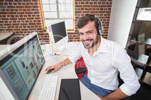 Smiling photo editor using computer in office