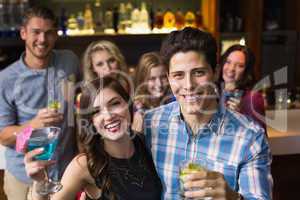 Happy friends drinking cocktails together