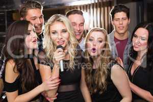 Happy friends singing karaoke together