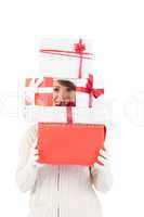 Festive young woman holding pile of gifts