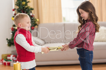 Festive siblings pulling a cracker