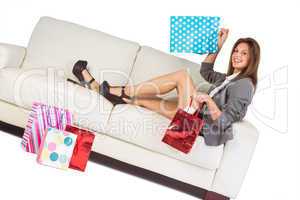 Woman lying on couch with shopping bags