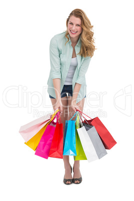 Smiling woman standing with many shopping bags