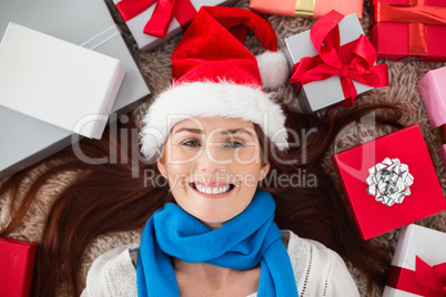 Festive redhead smiling at camera with gifts