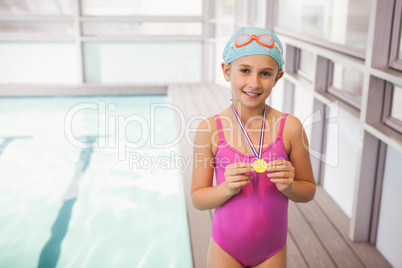 Cute little girl showing her swimming medal