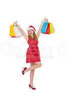 Pretty woman in santa hat holding up shopping bags