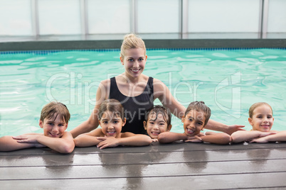 Cute swimming class in pool with coach