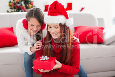 Festive mother and daughter with a christmas gift