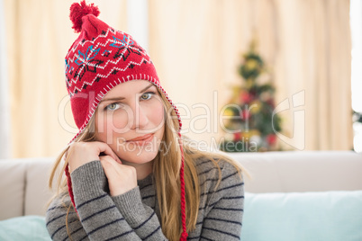 Pretty blonde in winter clothes sitting on the couch