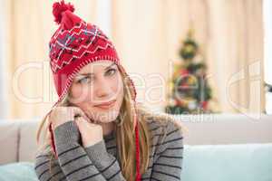 Pretty blonde in winter clothes sitting on the couch