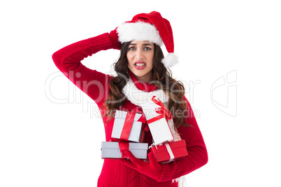 Stressed brunette in santa hat holding gifts