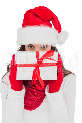 Brunette in red gloves and santa hat showing gift