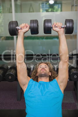 Man exercising with dumbbells in gym