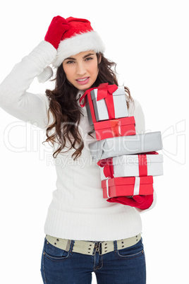 Stressed brunnette in santa hat holding gifts