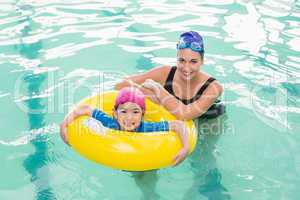 Cute little boy learning to swim with coach