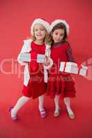 Festive little girls smiling at camera with gifts