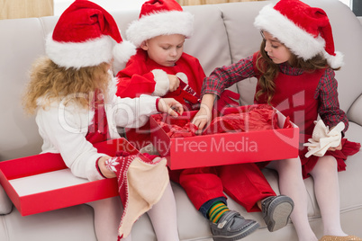Festive little siblings opening a gift
