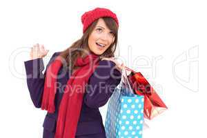 Happy brunette in winter clothes holding shopping bags