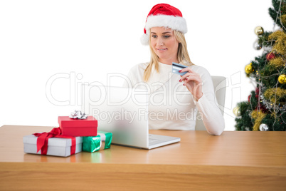 Festive blonde shopping online with laptop