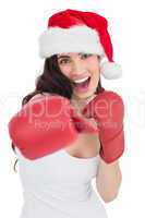 Festive brunette in boxing gloves punching