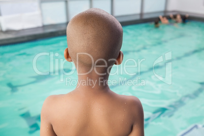 Cute little boy standing at the pool