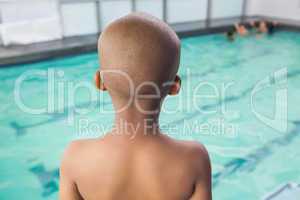 Cute little boy standing at the pool