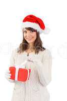 Smiling young woman in santa hat opening a gift