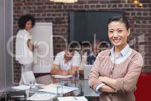 Smiling young businesswoman with colleagues in background