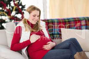 Pregnant woman rubbing her belly on the couch