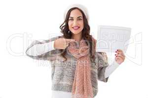 Brunette in winter clothes showing sale sign