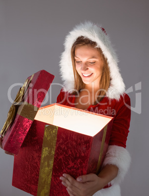 Festive pretty brunette opening a gift