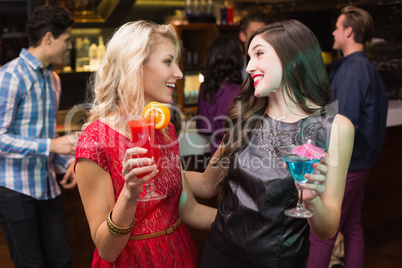 Pretty friends drinking a cocktail