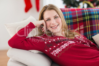 Content woman lying on the sofa smiling at camera