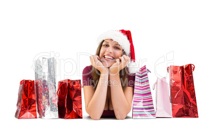 Festive brunette smiling at camera with gift bags