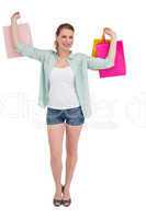 Smiling young woman holding up shopping bags