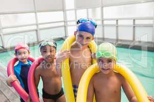 Cute swimming class smiling poolside