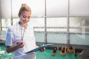 Pretty swimming coach standing poolside