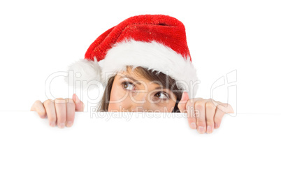 Festive brunette holding a poster while looking up