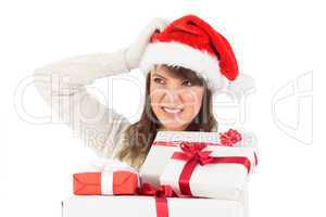 Cute brunette scratching head and holding gifts