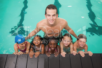 Cute swimming class in pool with coach