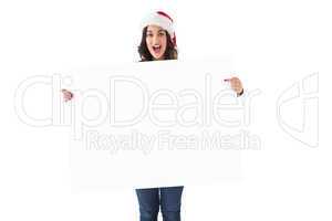 Pretty brunette in santa hat pointing white poster