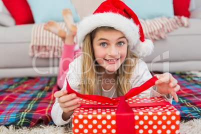 Festive little girl opening a gift