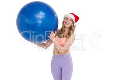 Smiling blonde woman holding exercise ball