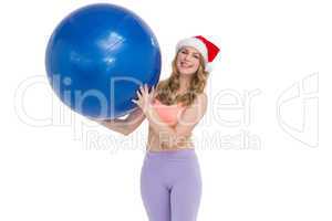 Smiling blonde woman holding exercise ball