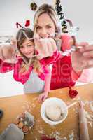 Festive mother and daughter making christmas cookies