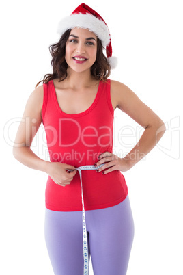 Festive athletic brunette measuring her waist