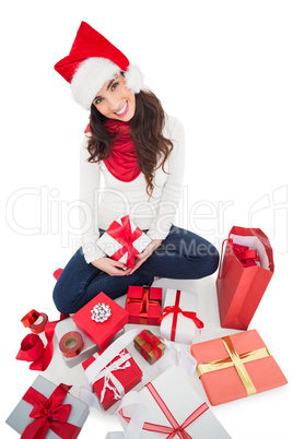Festive brunette sitting and wrapping christmas presents